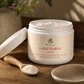 GutNaturals L-Glutamine powder tub open with a wooden scoop of powder on a sunlit oak counter